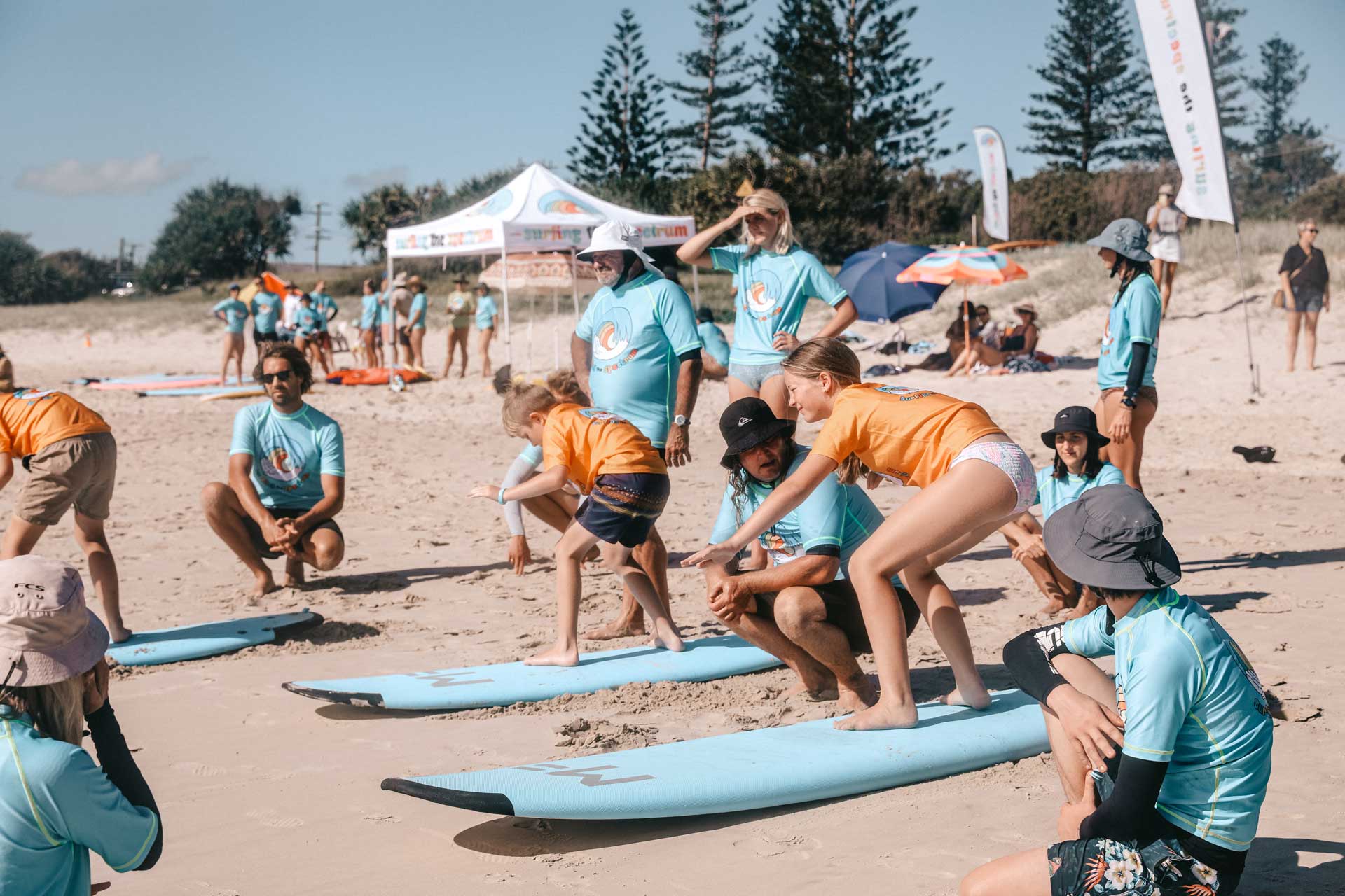 Group of young people and adults in a surf lesson on the beach