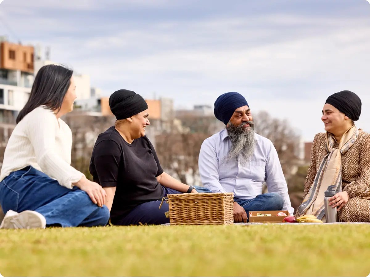 A group of people sitting around in a circle having a picnic while having the discussion 