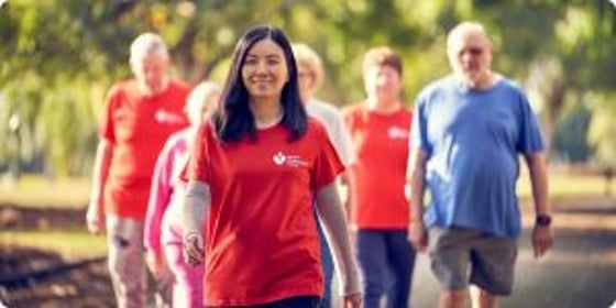 Woman in red Heart Foundation t-shirt walking ahead of a group of walkers