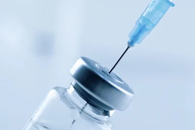 Syringe needle going into a medicine vile