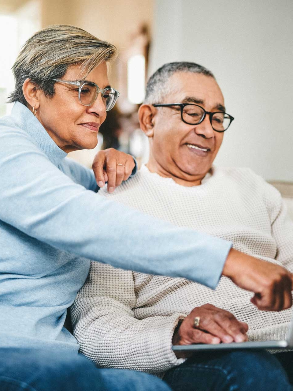 A senior couple using a laptop at home.