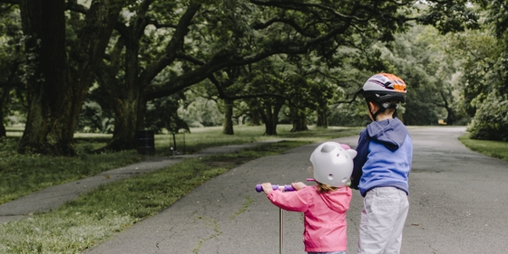 two children riding scooter
