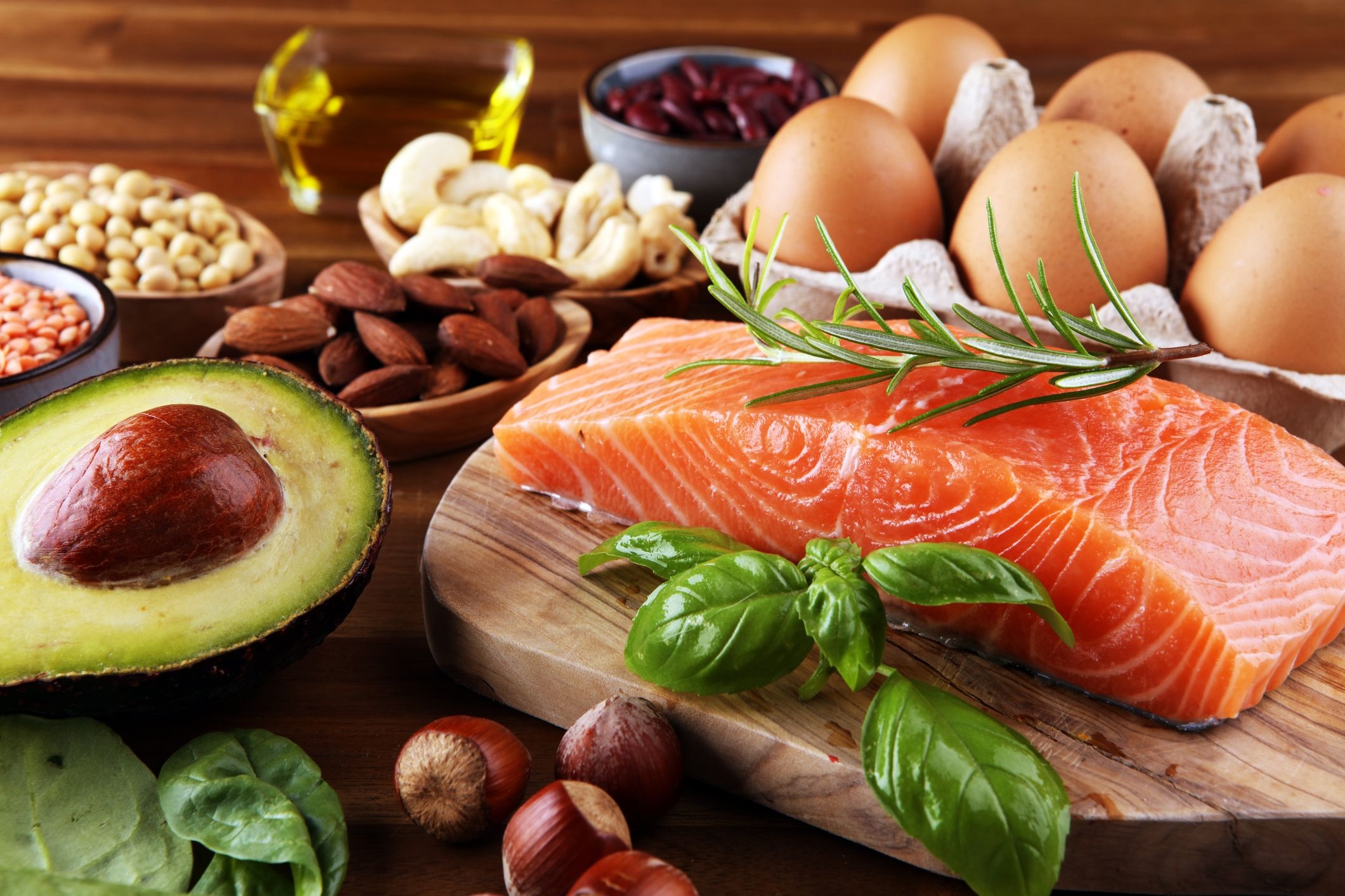Selection of healthy food for heart, including foods rich in Omega-3 and Omega-6 such as fish, nuts, oils and avocado.