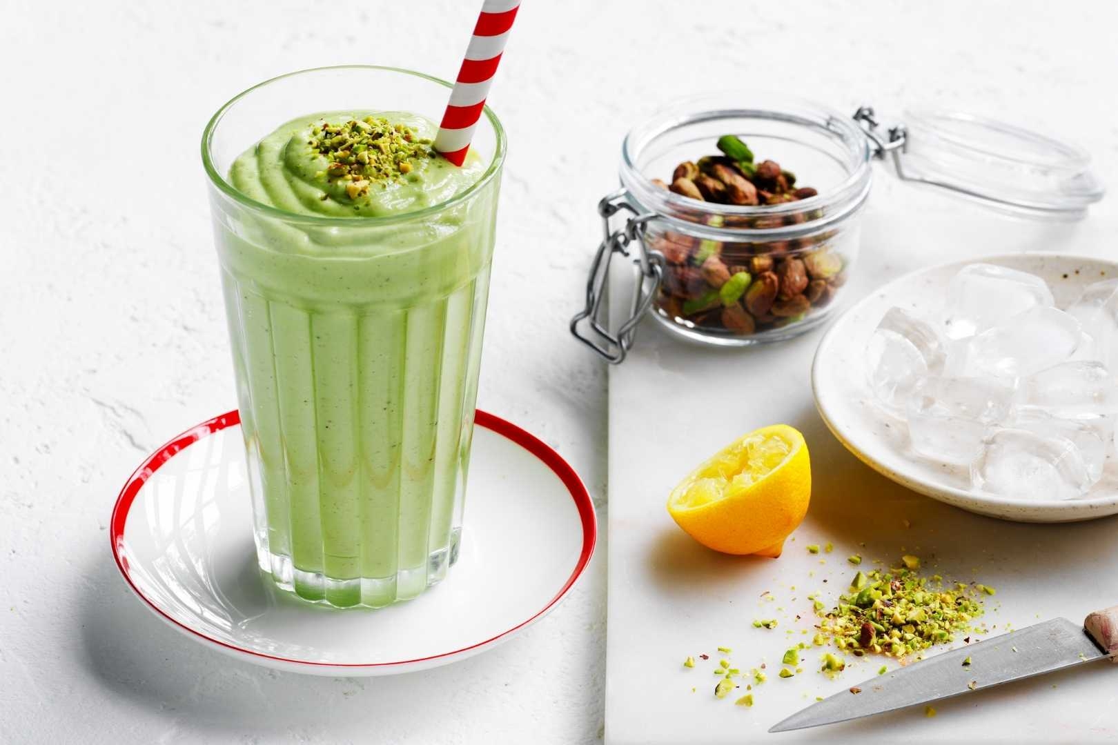 Pistachio smoothie in a tall glass served on table