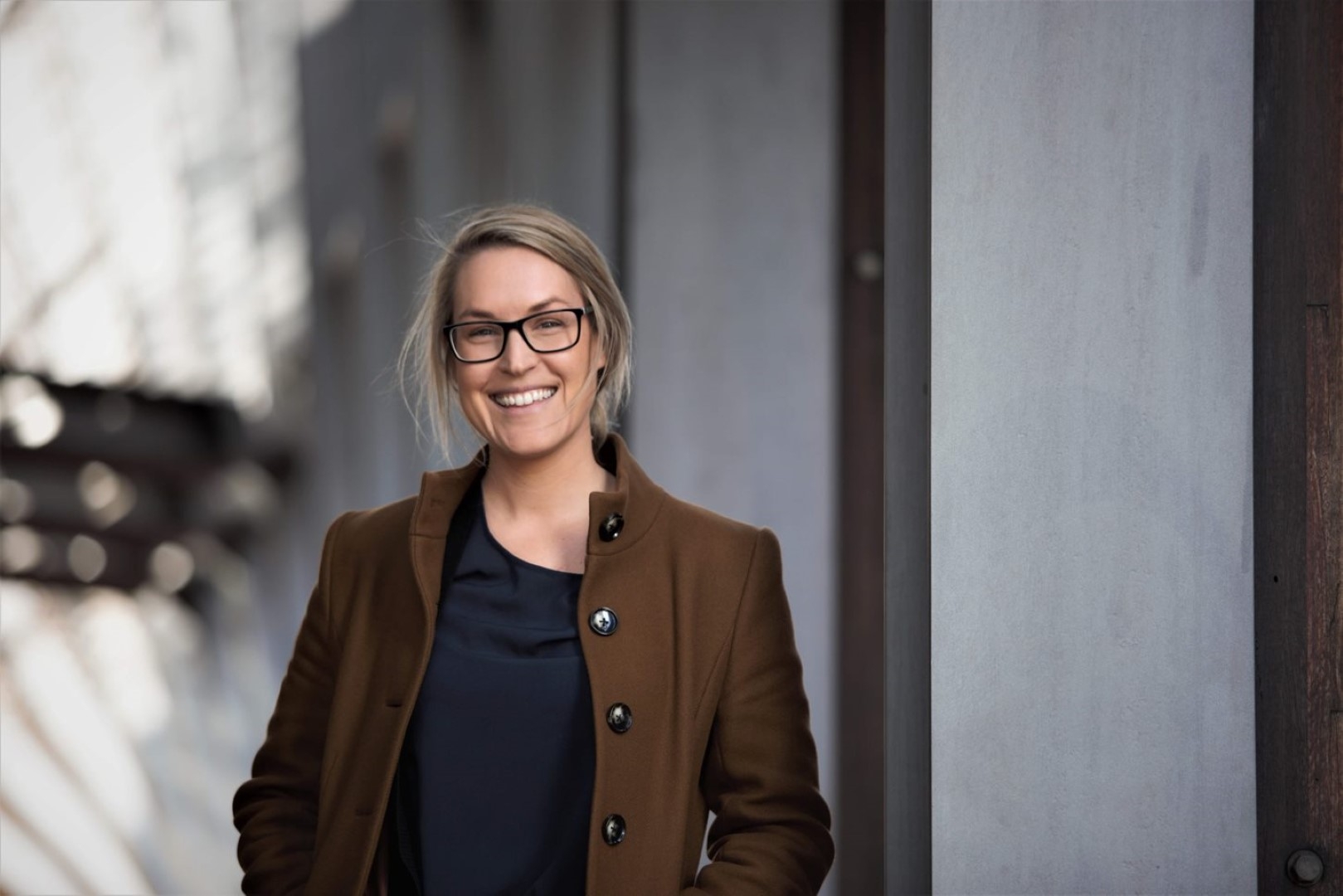 Dr Lauren Blekkenhorst smiling with blurry urban structures behind her