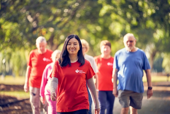 Woman in red Heart Foundation t-shirt walking ahead of a group of walkers