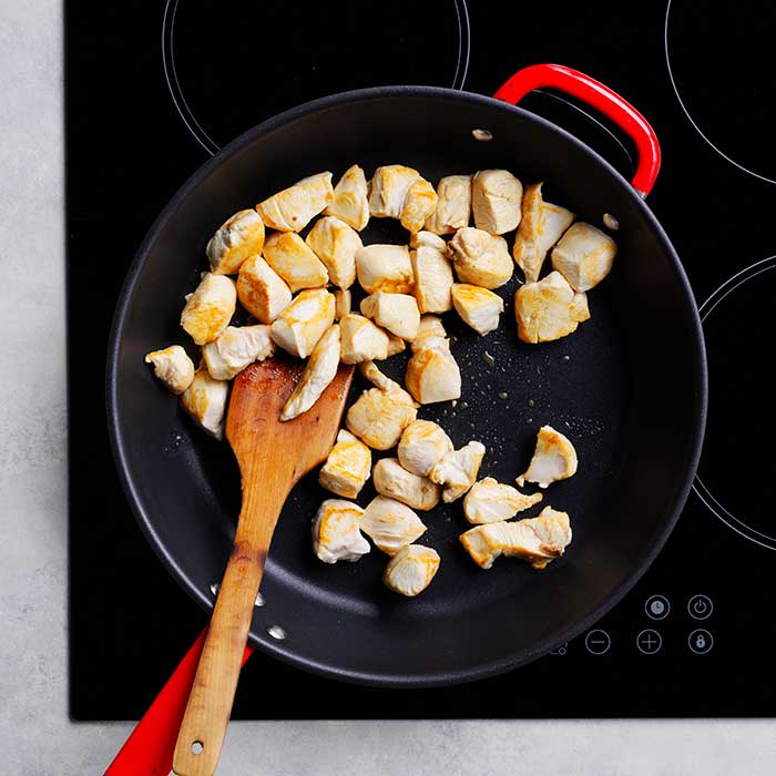 chicken pieces cooking in a pan