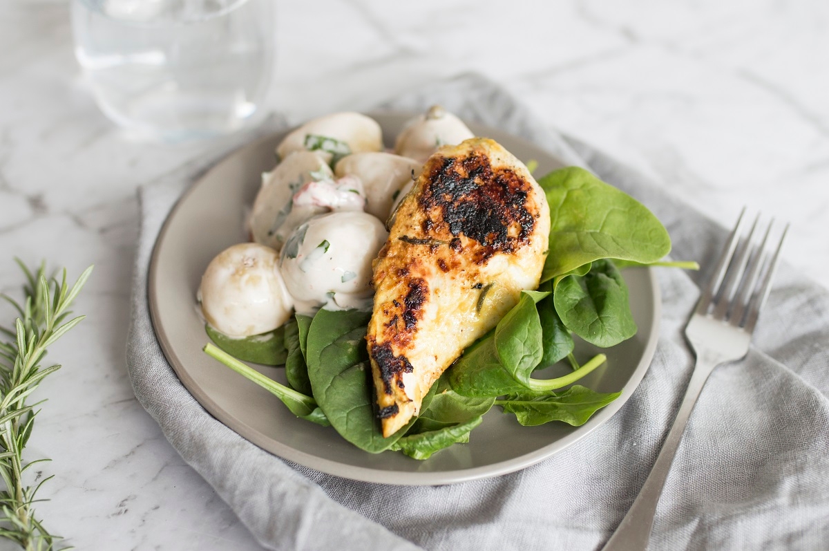 Grilled chicken breast served with potatoes and spinach