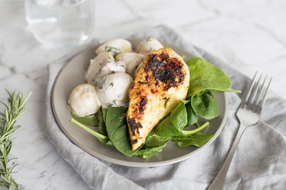 Grilled chicken breast served with potatoes and spinach