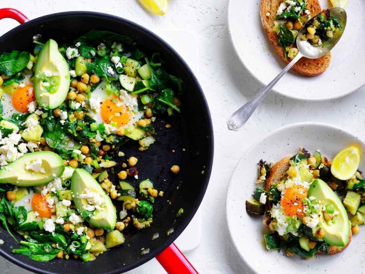 Green shakshuka for two completed dish in a pan in a table setting