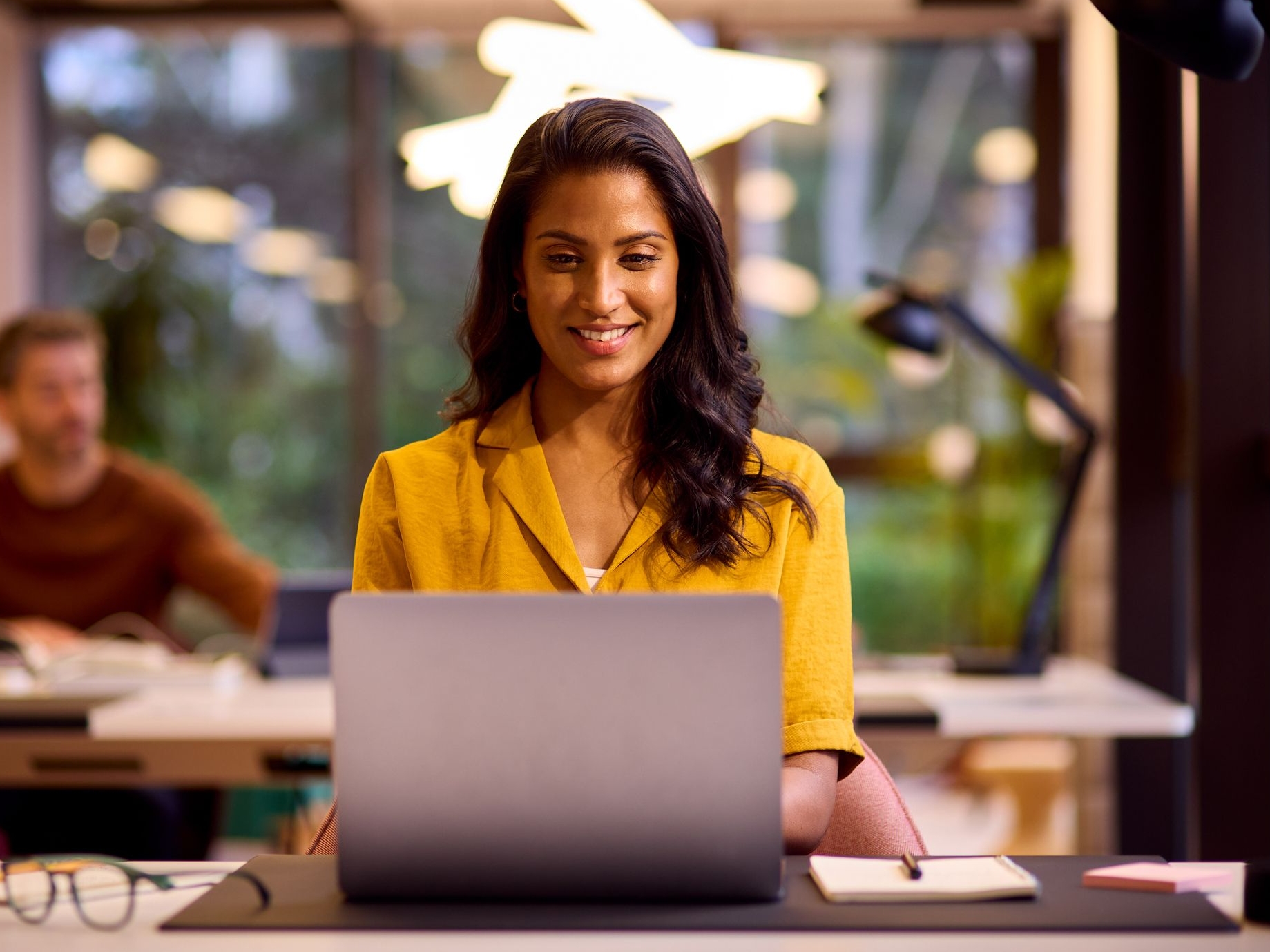 Mature businesswoman setting up her workplace giving on laptop at desk in office