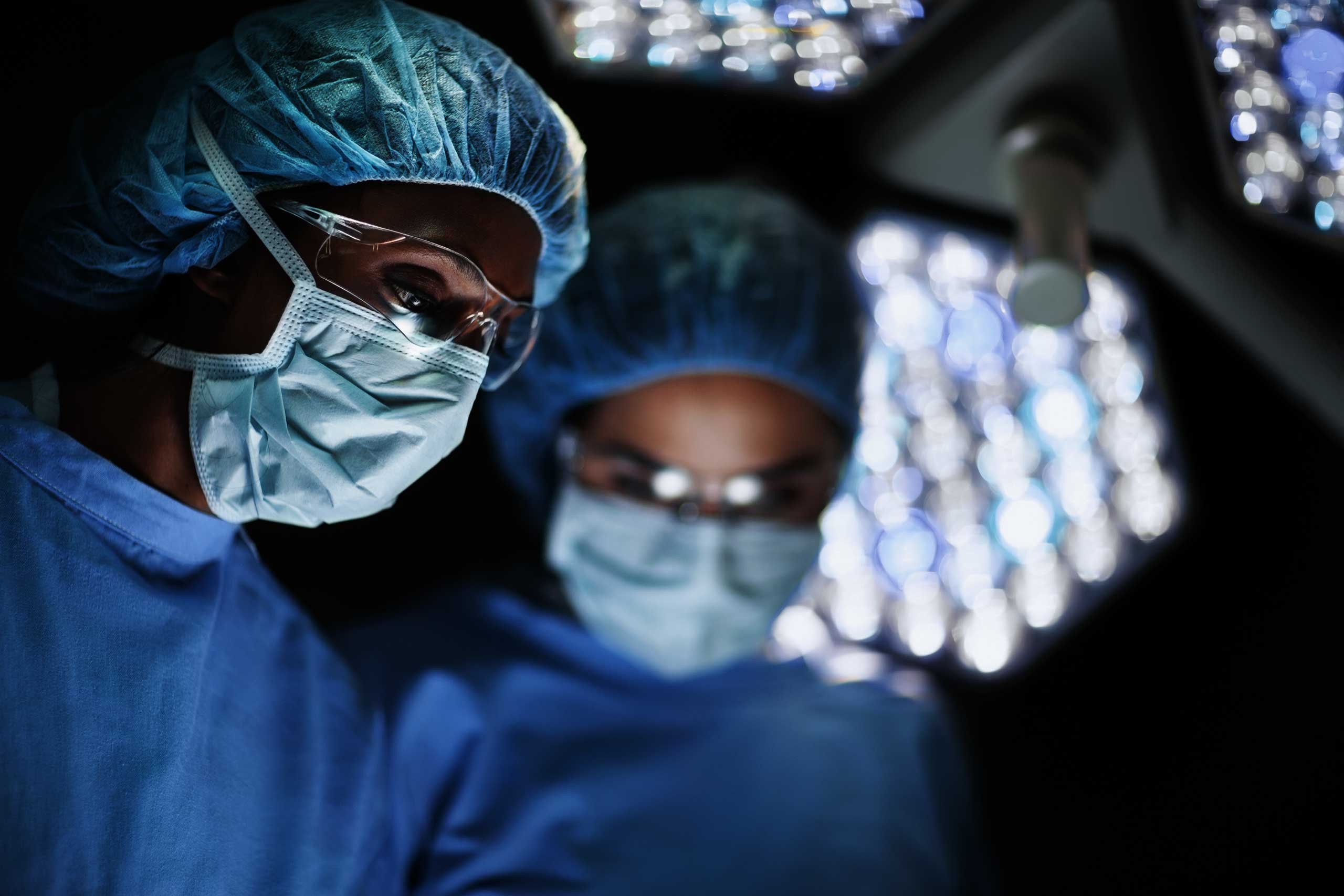 Healthcare professional in masks and scrubs in an operating theatre