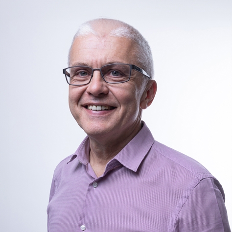 David Lloyd wearing a lilac shirt, smiling 