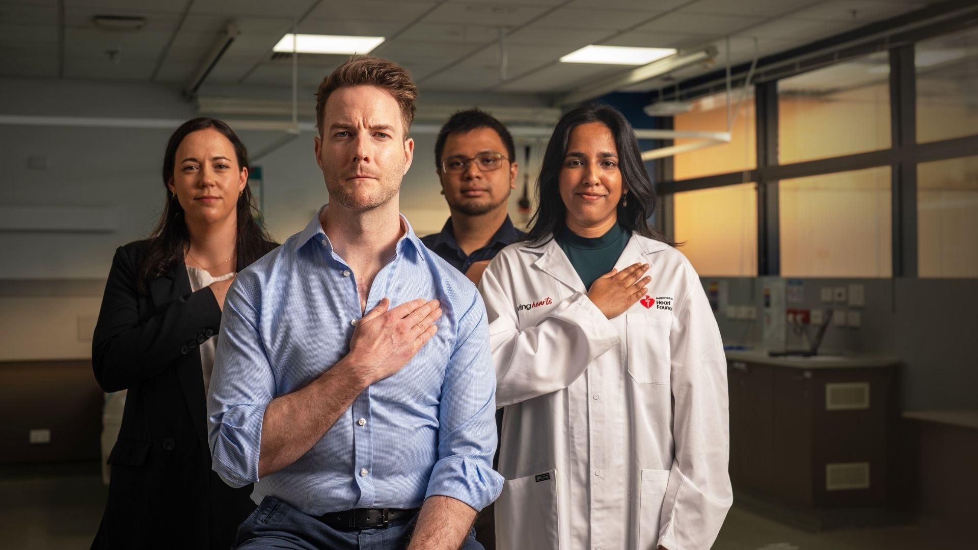 A group of Heart Foundation funded researchers with their hands over their hearts