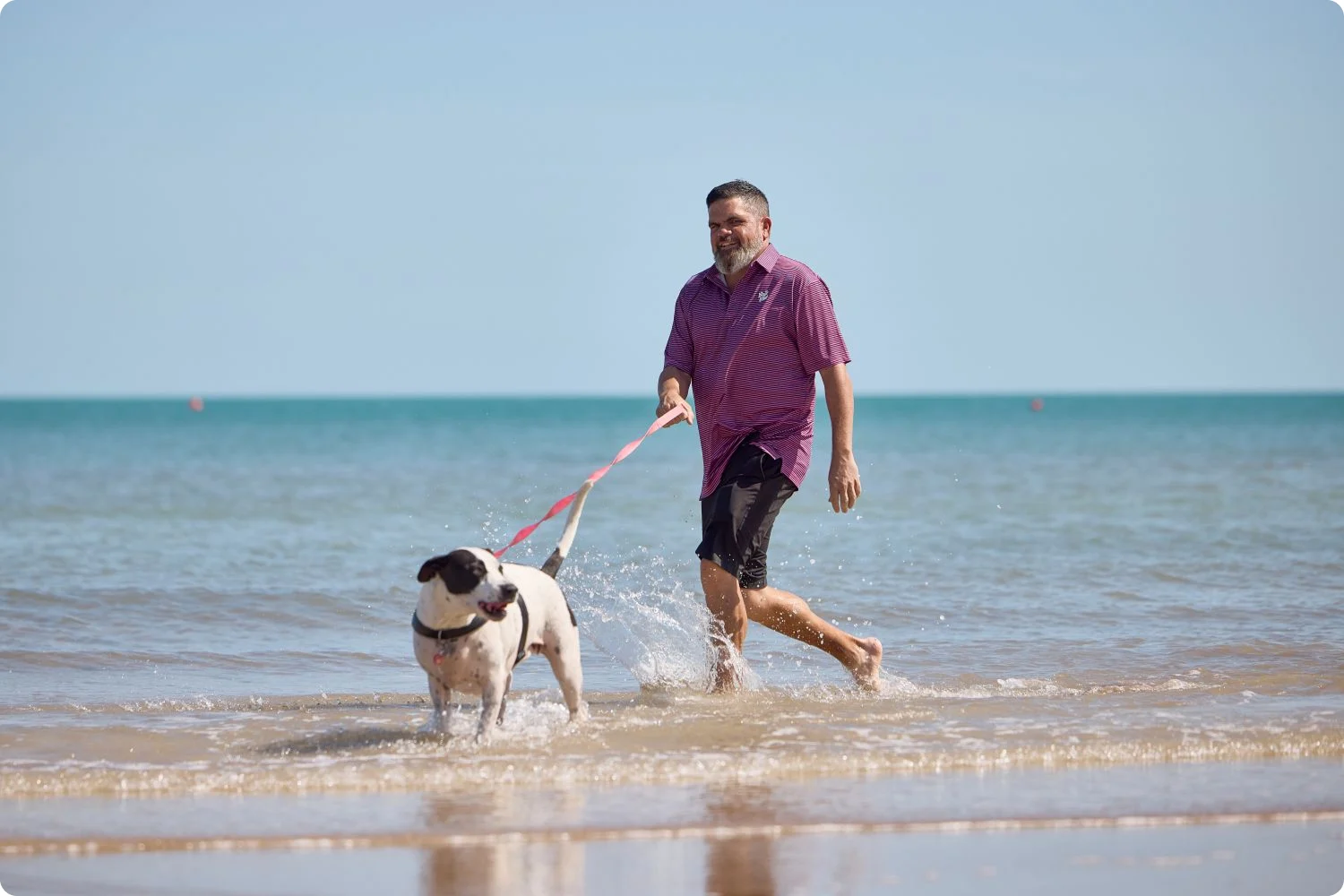 Kieran Bush running on the beach with dog Luna
