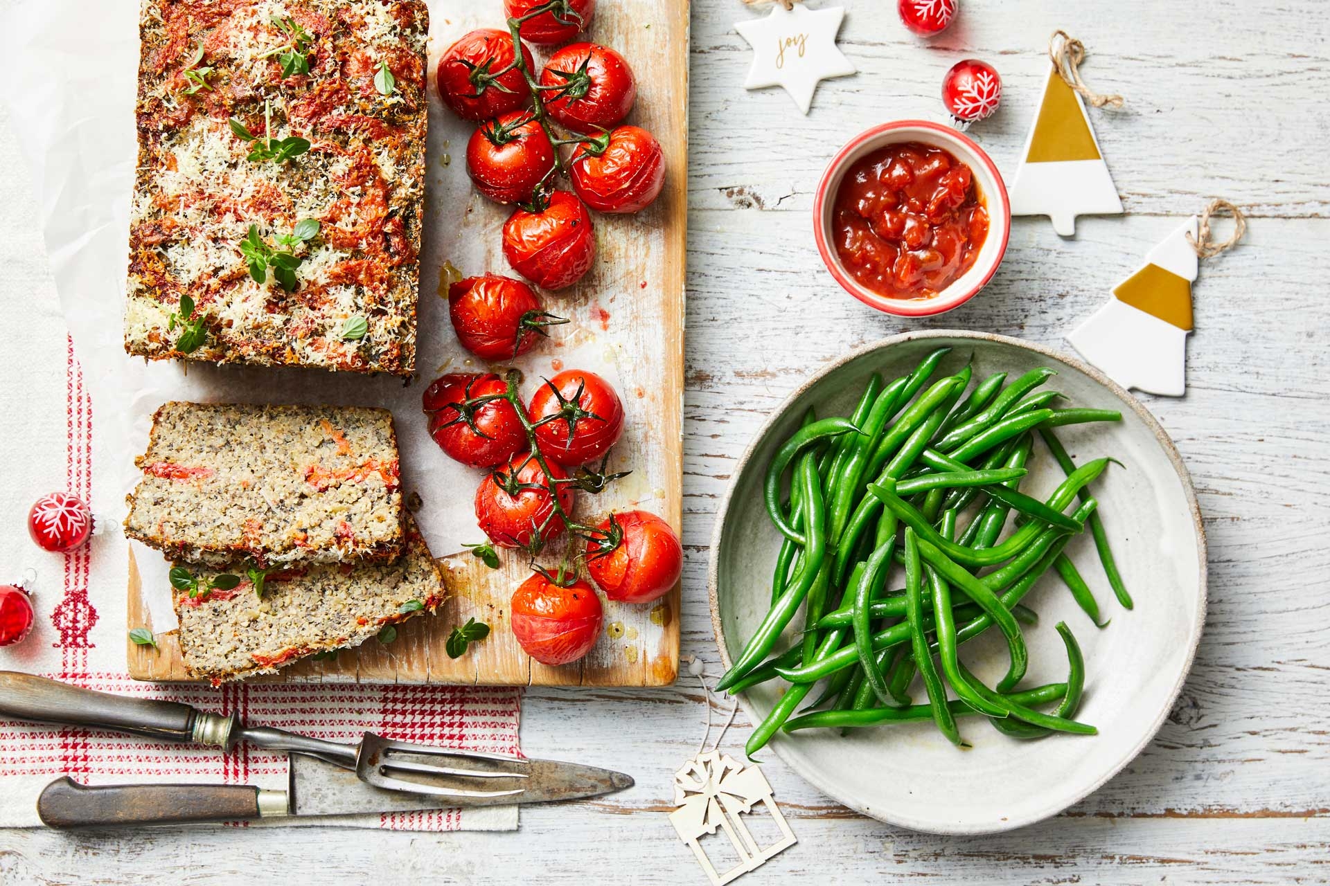 Rustic vegetarian loaf, crisp green beans and juicy tomatoes on a wooden board.