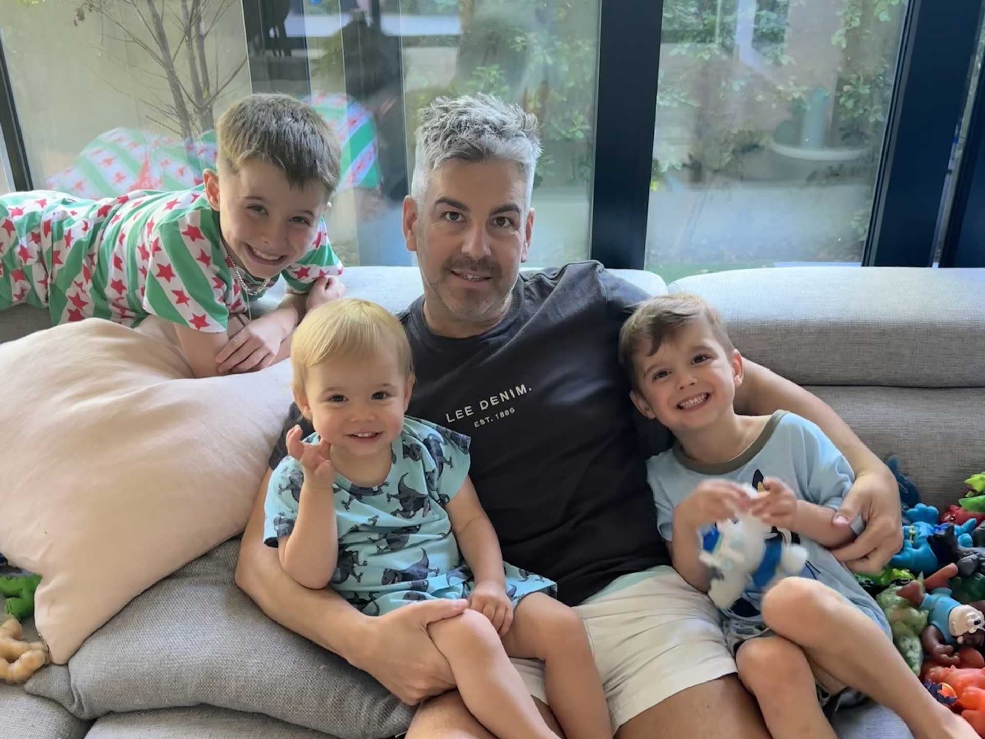 Heart attack survivor Jarrod with his three boys on couch at home