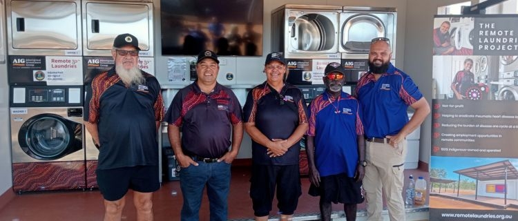 A group a people including Aboriginal Australians, standing in front of a community laundry