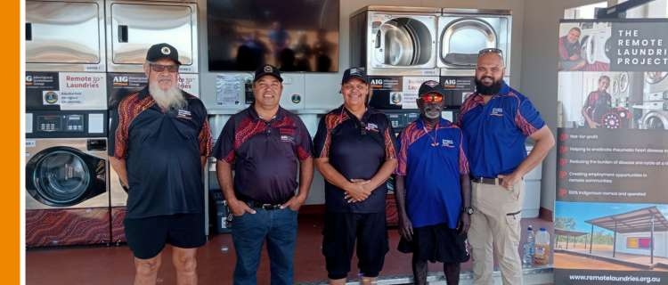 A group a people including Aboriginal Australians, standing in front of a community laundry