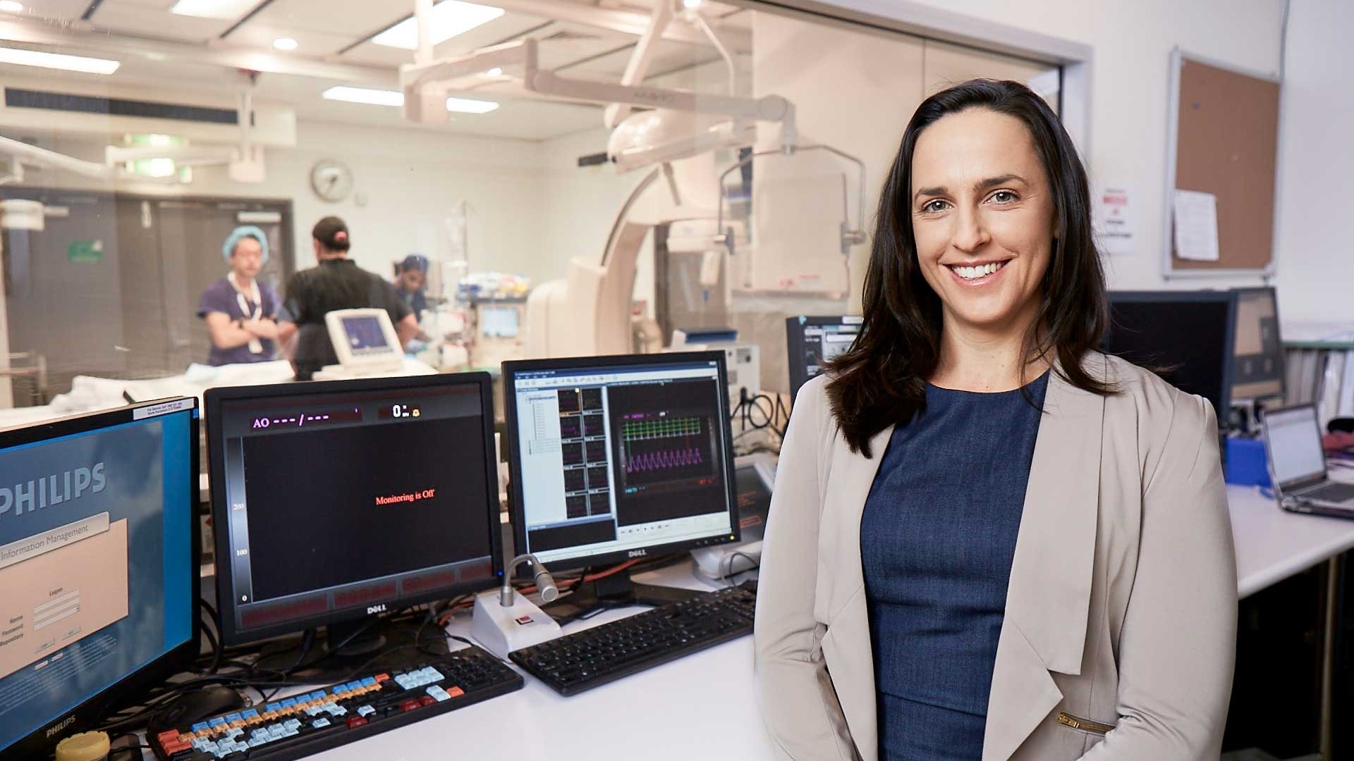 Associate Professor Sarah Zaman in a medical room smiling at the camera