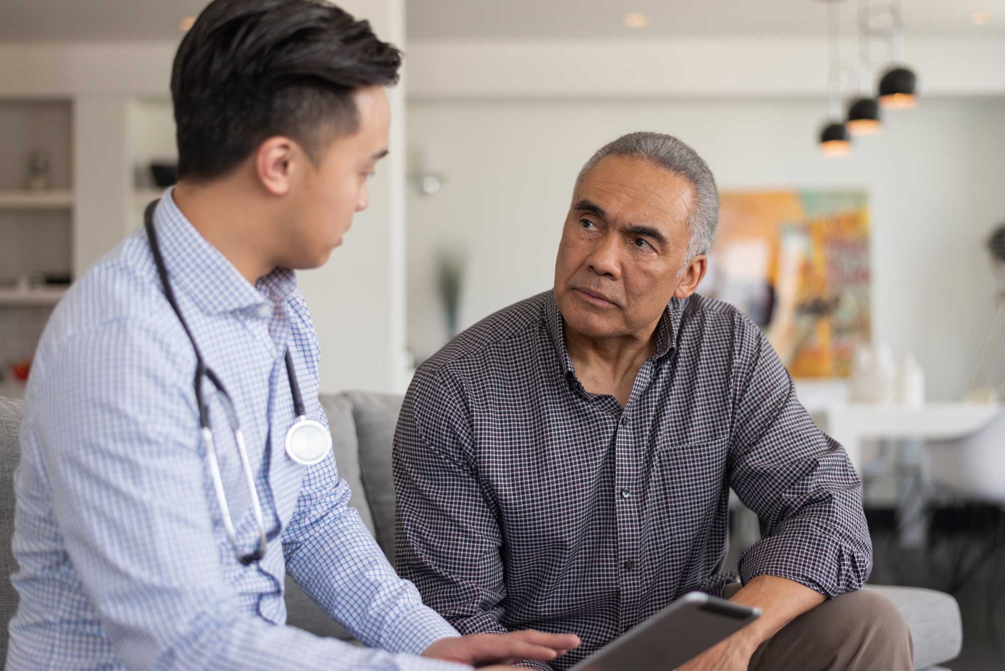 Two men talking in a consultation, one is older patient, other is a healthcare professional