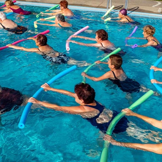 Group participating in a water aerobics class in a swimming pool.
