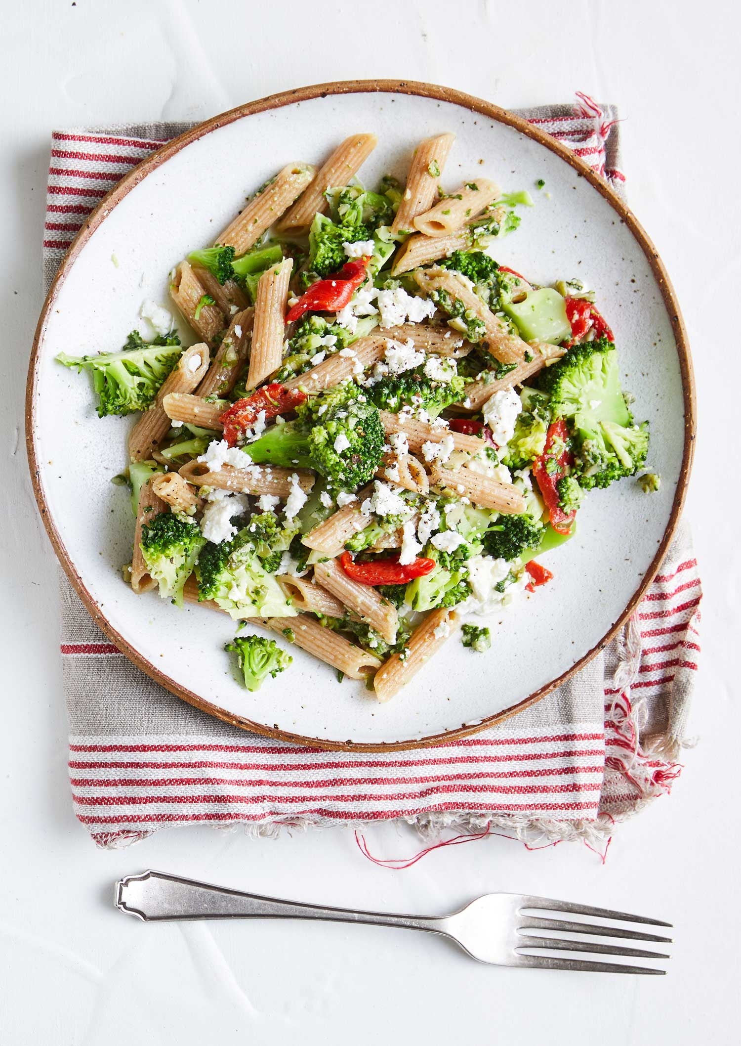 Plate of colourful vegetarian penne pasta with broccholi 