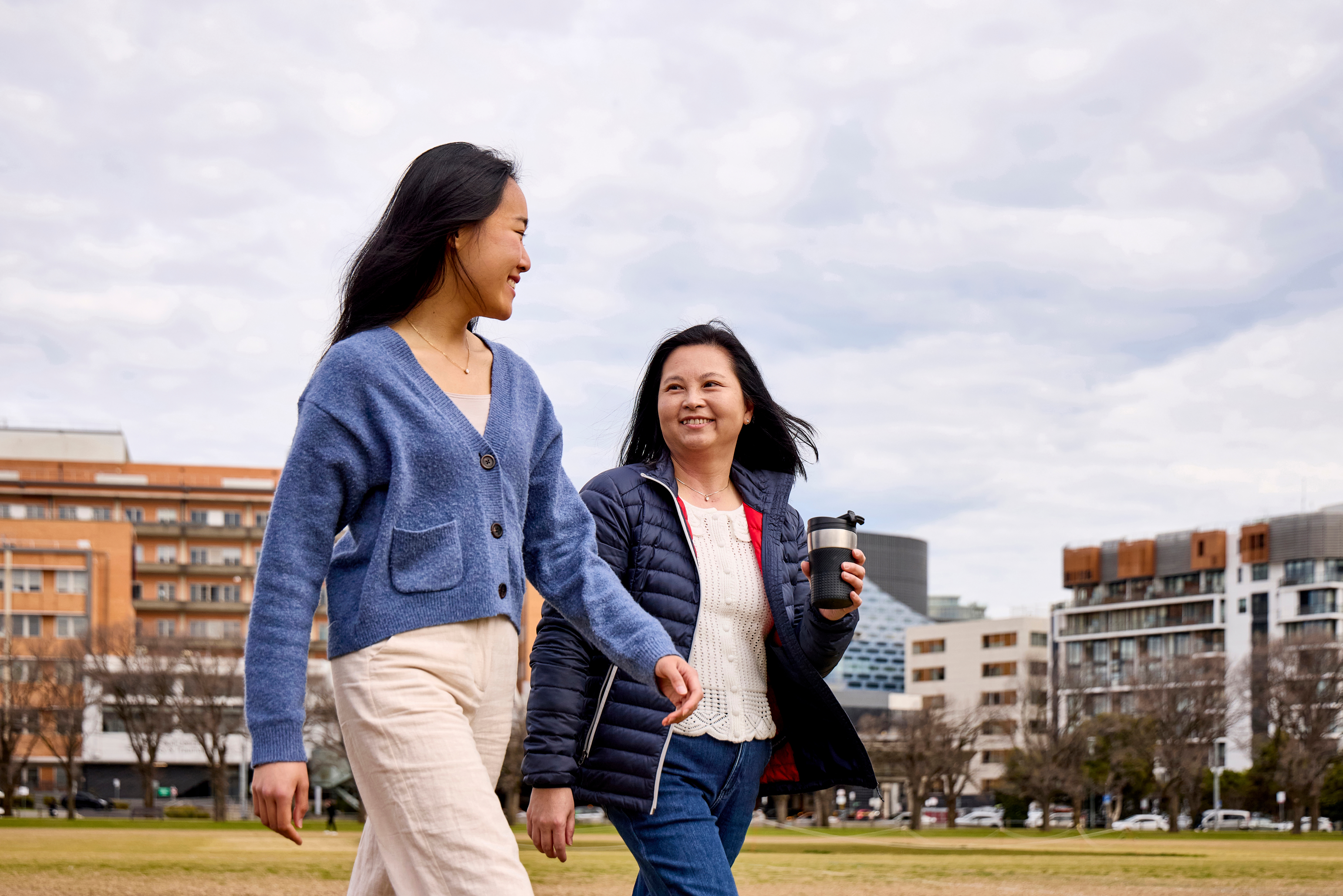 Two Vietnamese women walking through the park