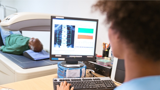 A person looking a computer screen that is conducting blood vessel calcification screening