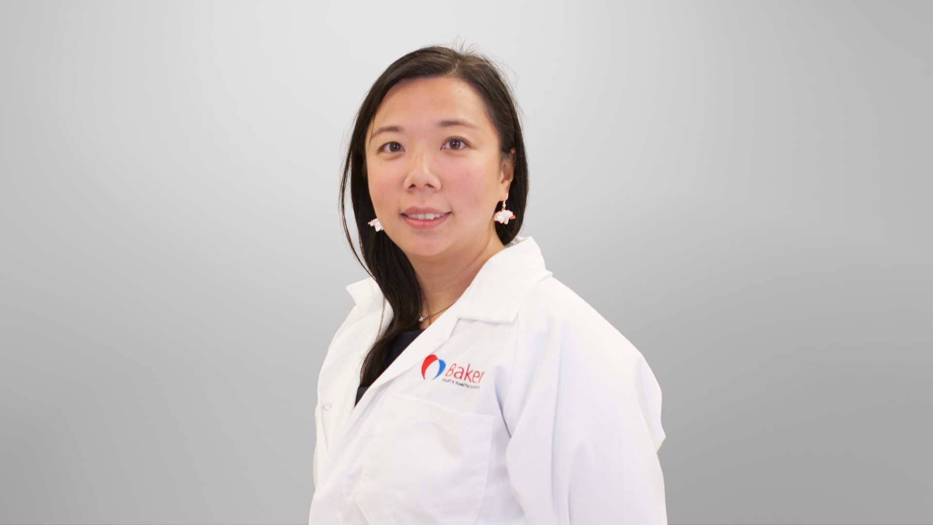  Associate Professor Xiaowei Wang wearing lab coat and smiling