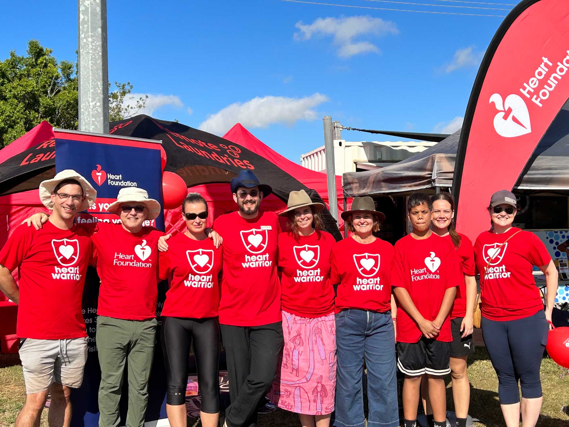 Group of people in red Heart Foundation t-shirts in front of tent at Barunga Festival 2023