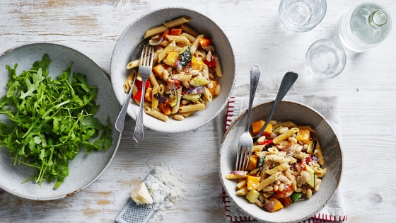 Two bowls of penne pasta on a table