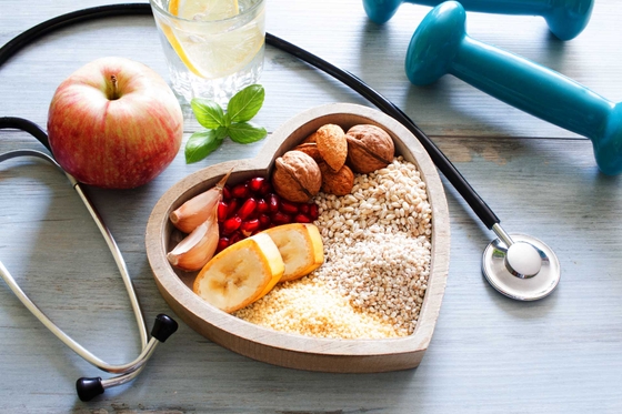 Fruit and grains in a heart shaped bowl on a table. 