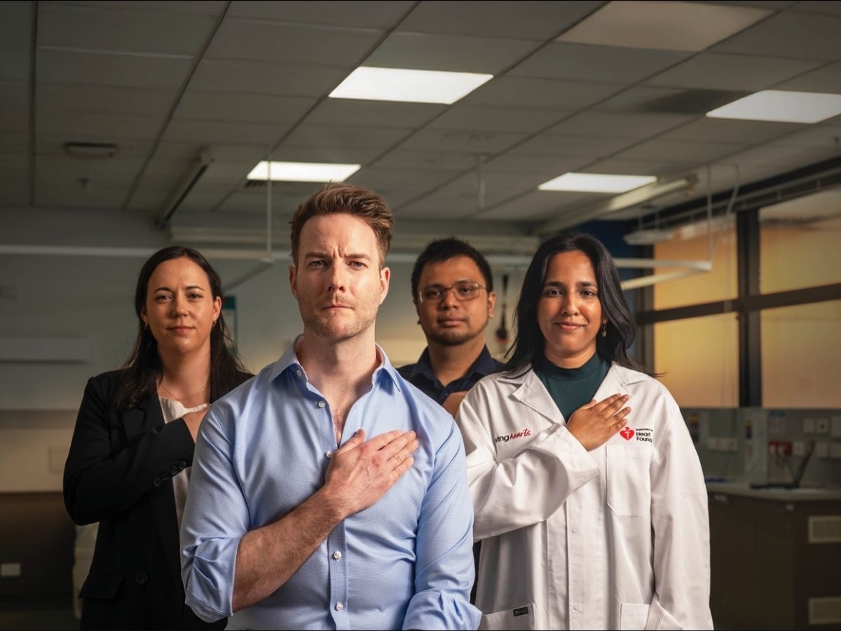 A group of Heart Foundation funded researcher standing with their hands over their hearts