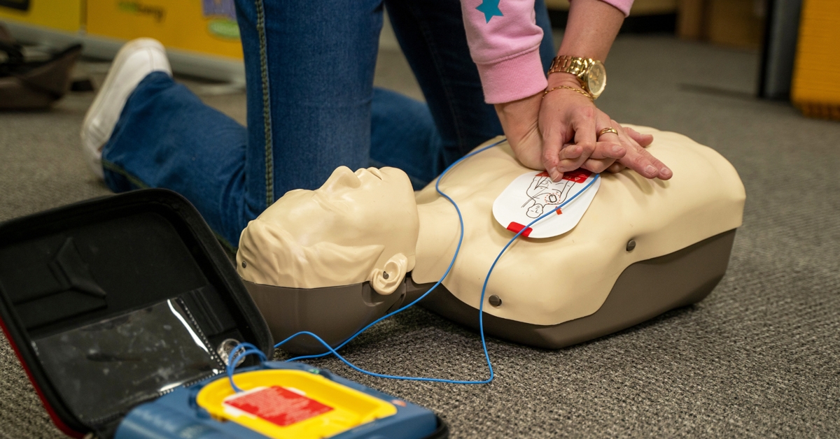 A woman practicing CPR on a mannequin