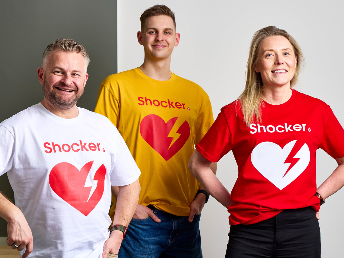 A bright red and white t-shirt with the AED heart icon and the word 'Shocker' written above. 