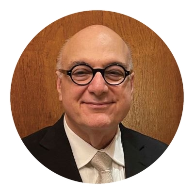 A man in glasses and a suit exudes professionalism and confidence.