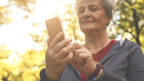 Mature woman holding a mobile device and looking at it