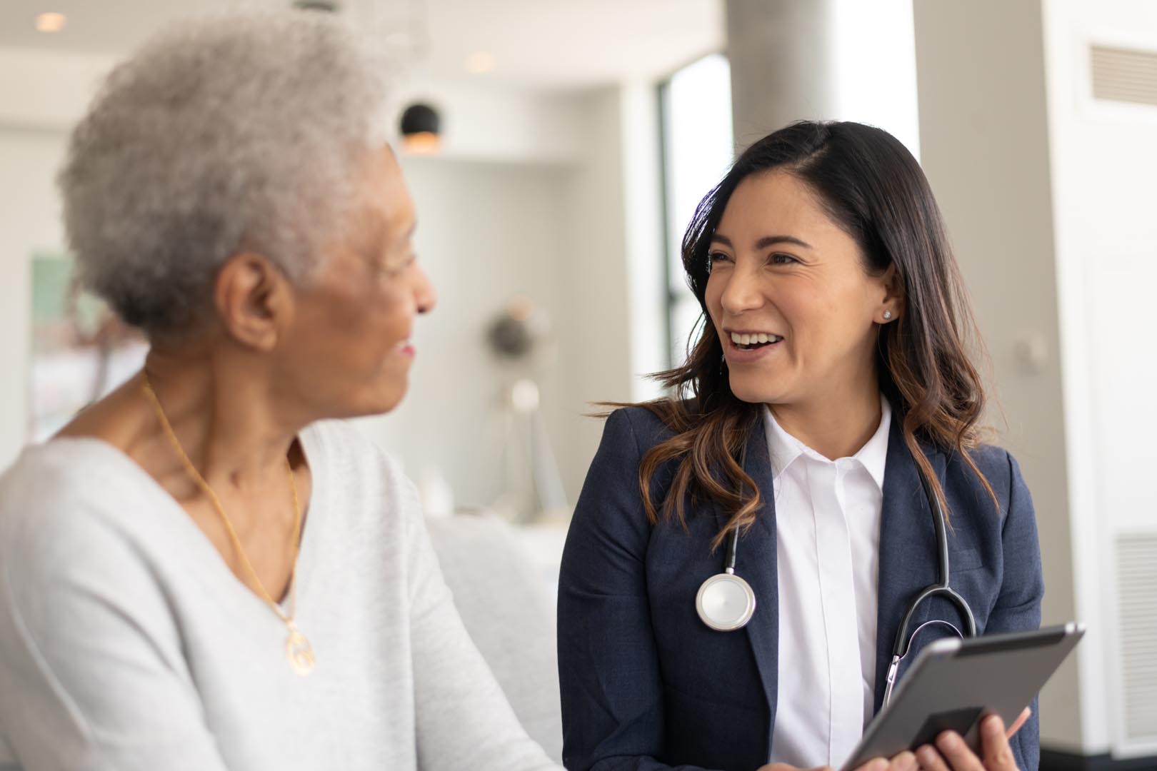 Young female health professional speaking with an elderly lady.