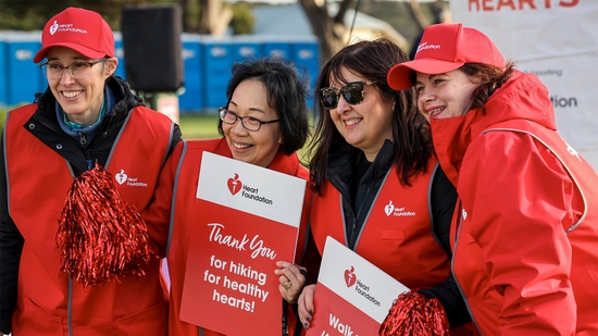 Heart Foundation team shot, 4 female staff holding a sign hiking for healthy hearts