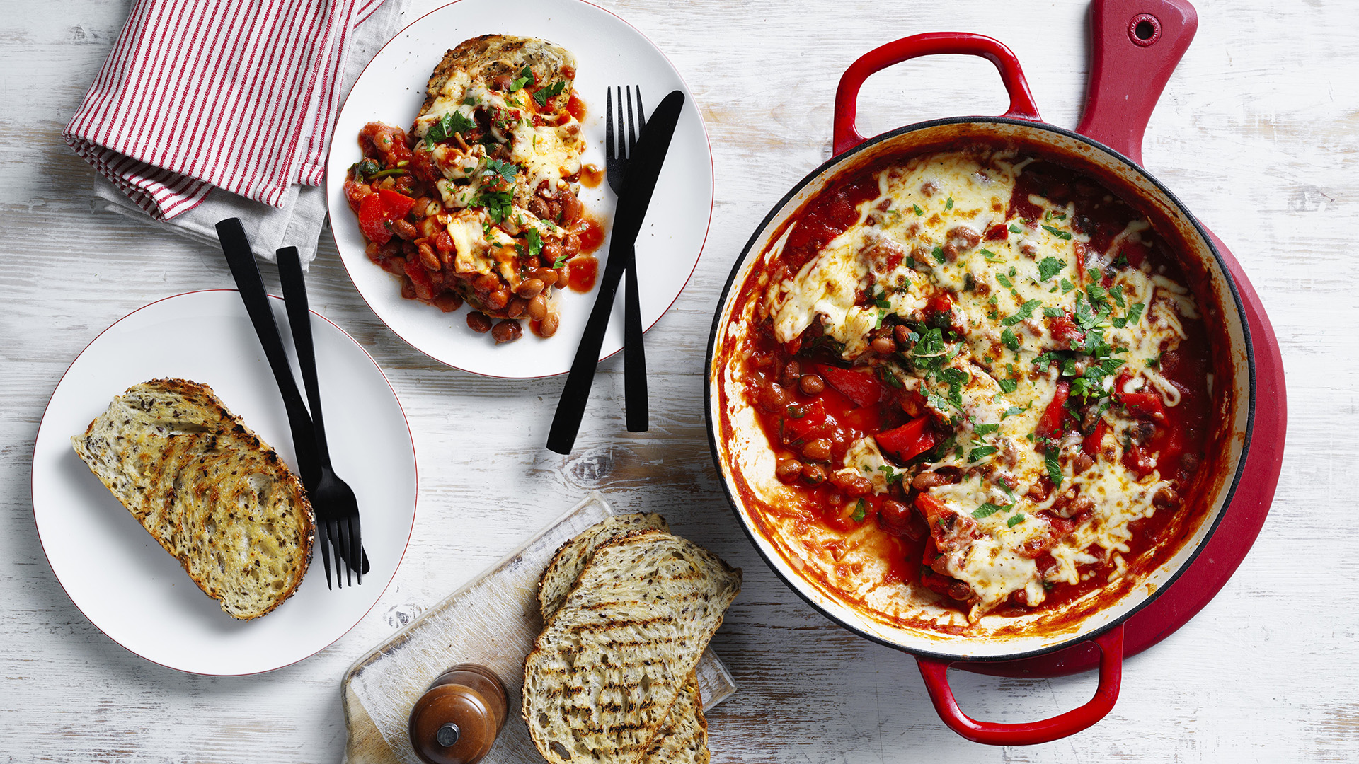 One pan beans pizzaiola served on a plate with the baking dish on the side