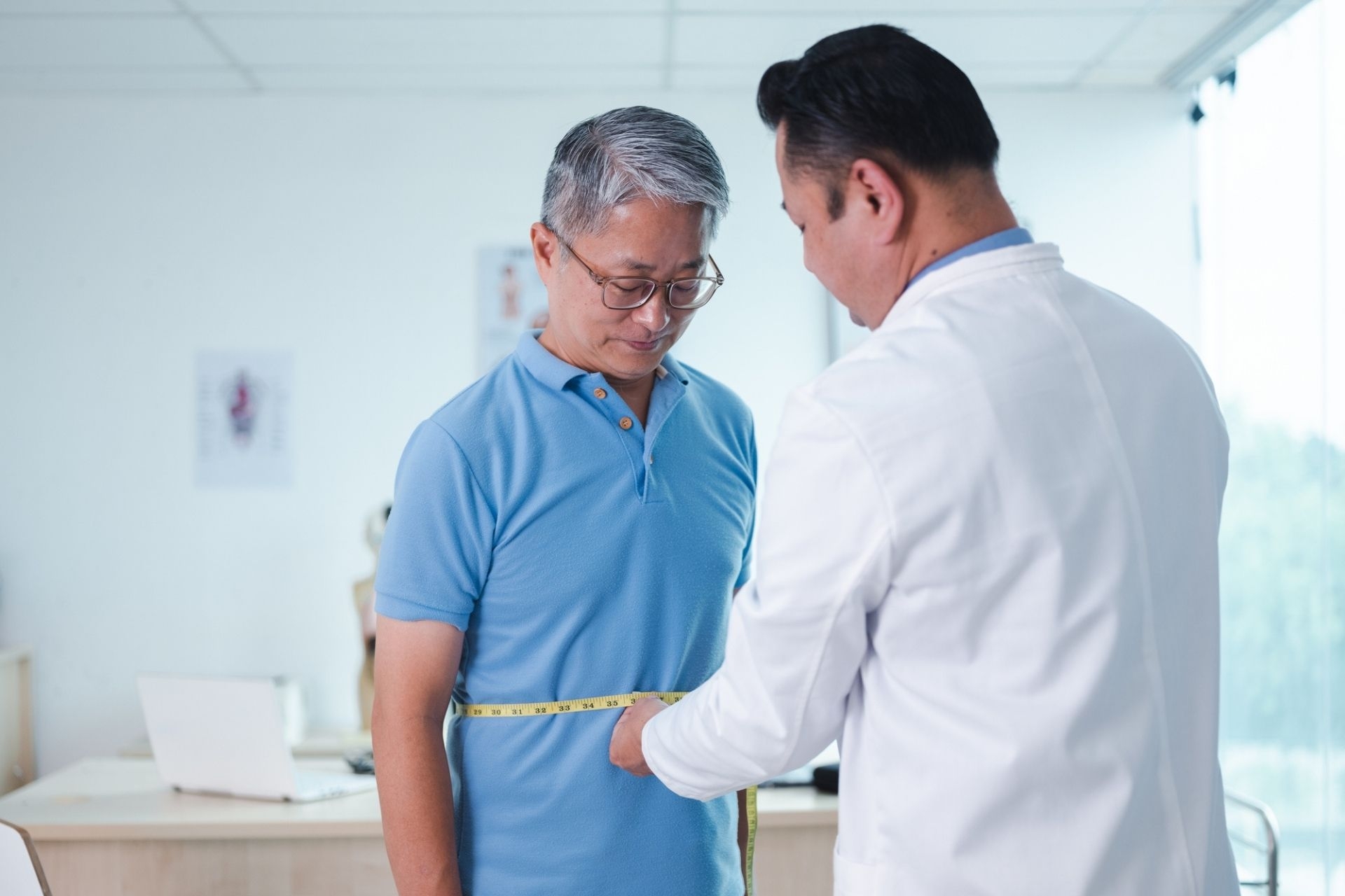 Doctor measuring patient's body part using a measuring tape in hospital