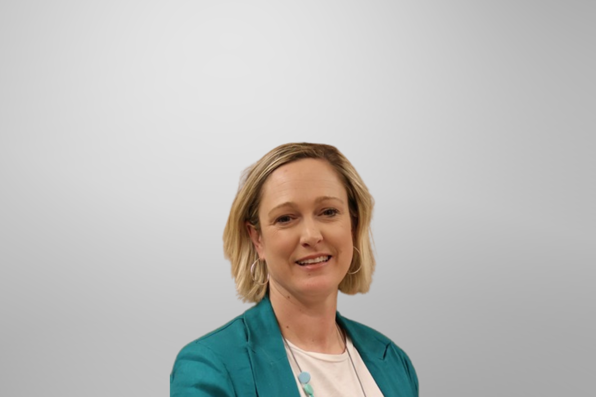 Anna Calkin wearing a green blazer and white shirt, smiling