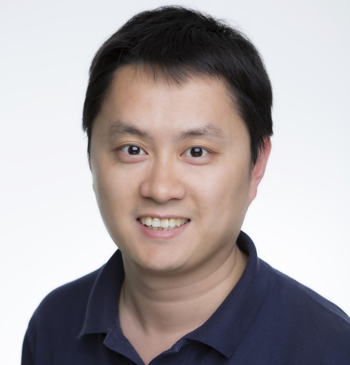 Dr Chenglong Yu smiling, wearing a black shirt.