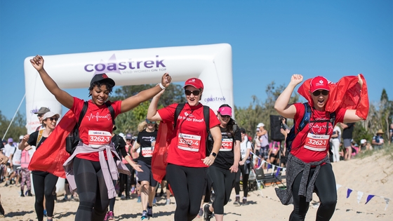 Heart Foundation team members celebrating at the finish line of a Coastrek event.