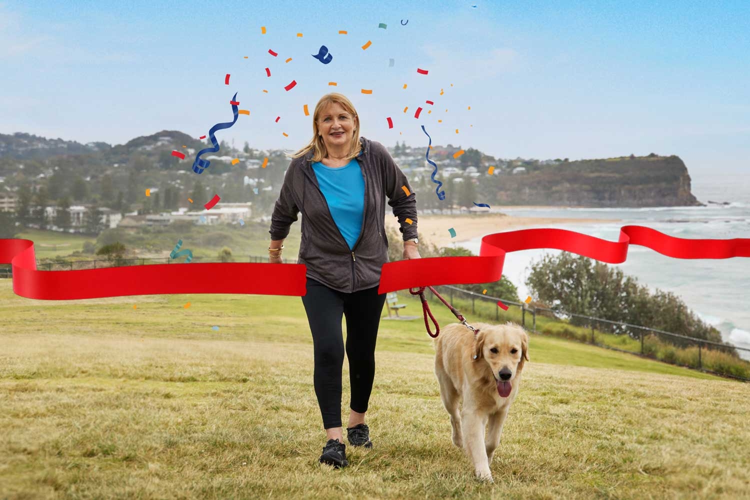 A woman is walking her dog up a hill 