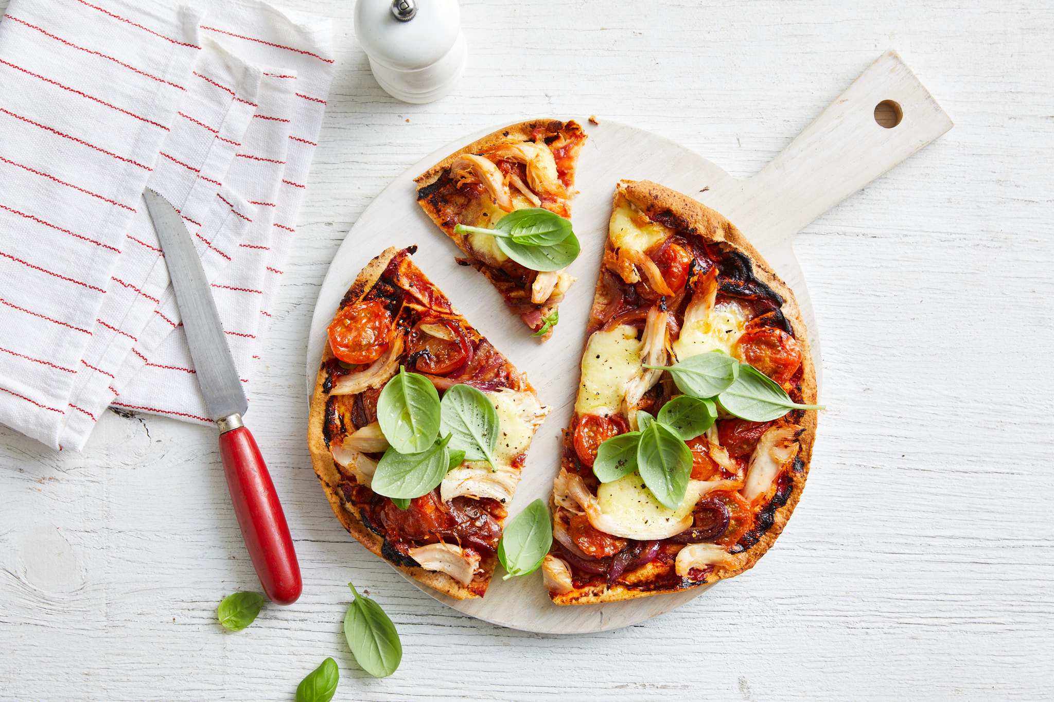 A delicious pizza topped with melted cheese, juicy tomatoes, and fresh basil leaves