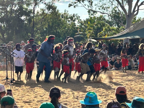 Group of First Nations kids and adults in traditional dance at Barunga Festival 2023