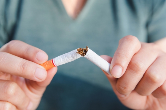 A person holding a cigarette in their hand, showcasing a common habit with potential health risks.