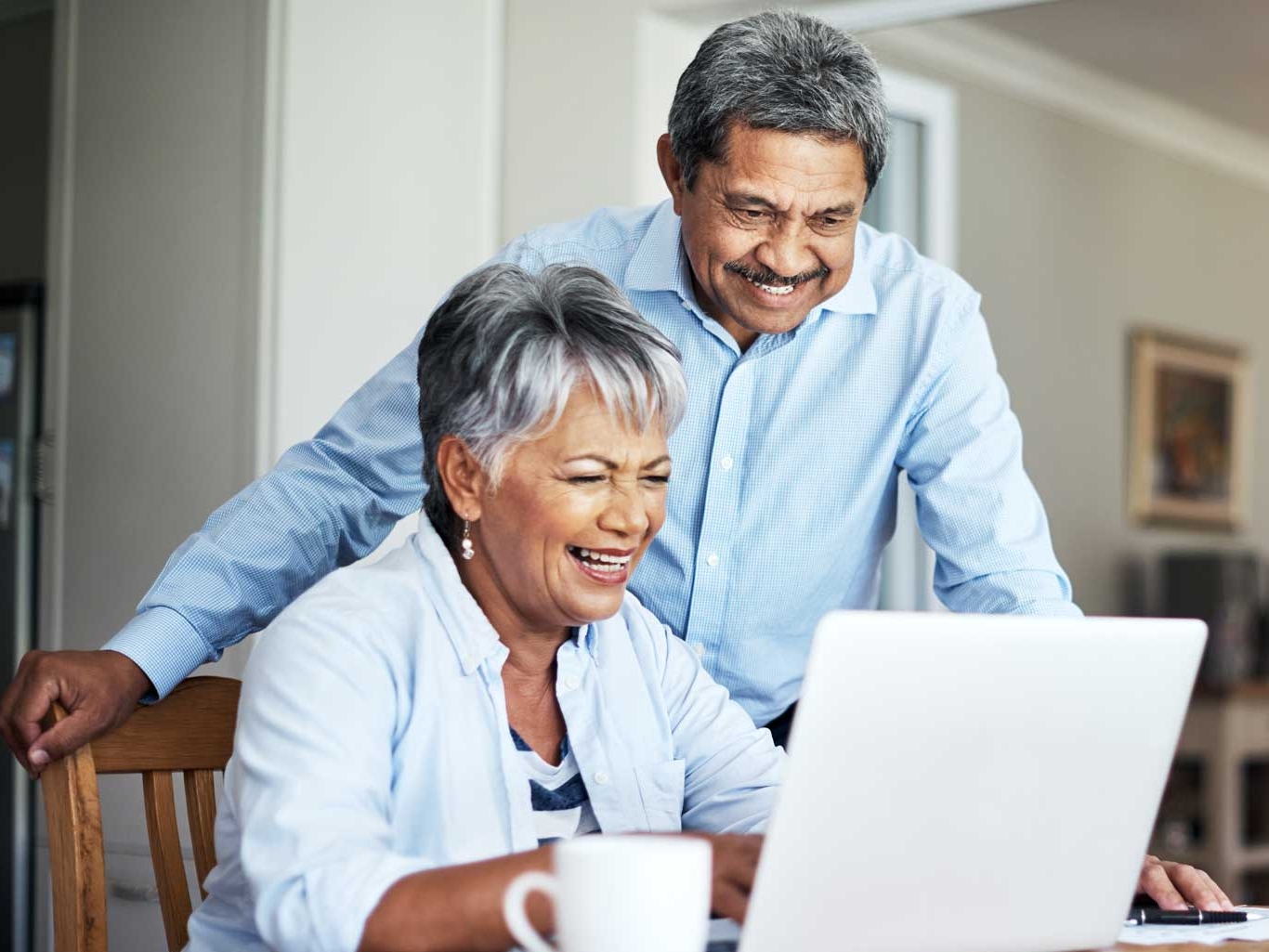 A senior couple using a laptop to do their household budget.